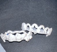 a pair of silver teeth on a black cloth